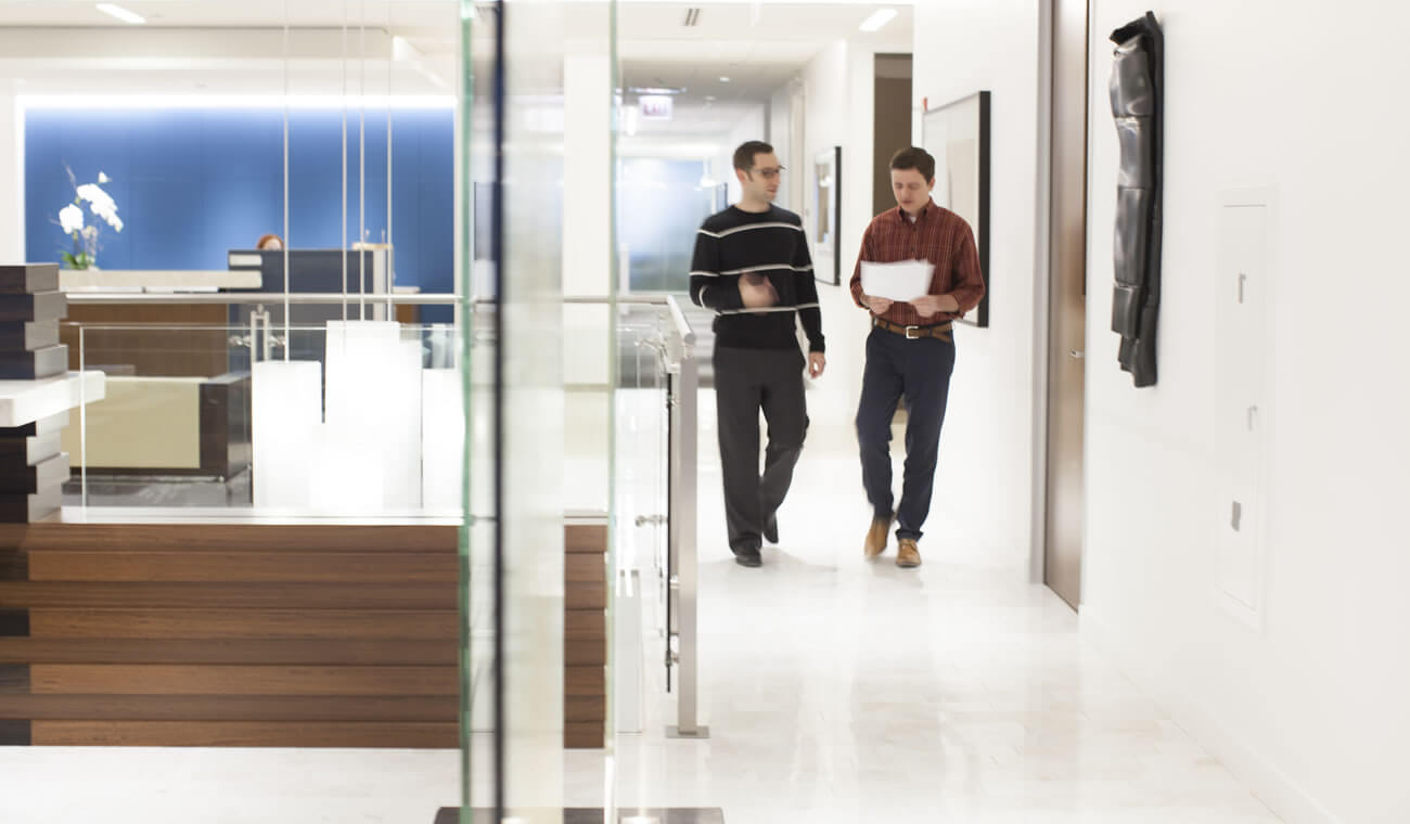 Two men in discussions walking down the hall